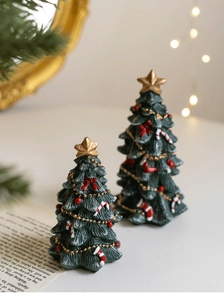 Close-up of resin mini Christmas trees with gold star toppers and festive ornaments
