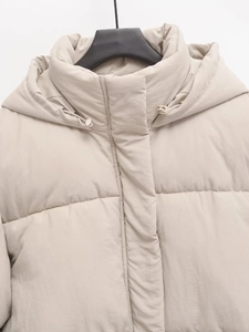 Women's chic beige hooded puffer jacket for winter with drawstring detail on a hanger