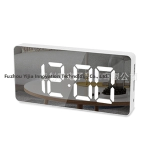 Close-up of modern white mirror digital clock showing LED time display and sleek finish