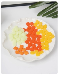 Macro shot of colorful PVC miniature cubes in green, orange, and yellow for DIY resin crafts