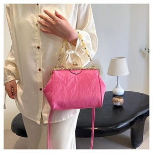 Detail of fuchsia pleated seashell bag with beaded handle and vintage metal clasp