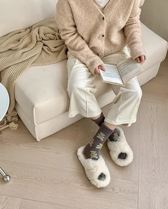 Detail of coral fleece socks with bear pattern and matching open-toe slippers for home