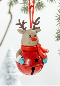 Detailed view of reindeer Christmas bells hanging on a snowy tree branch