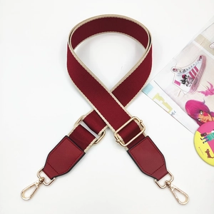 Close-up of burgundy woven strap with gold metal buckles and beige trim details