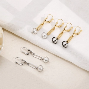 Three pairs of elegant long pearl earrings in gold and silver finishes on white fabric