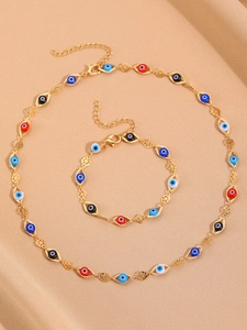 Golden Evil Eye jewelry set featuring colorful heart charms on silk background