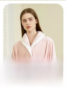 Close-up of pink coral fleece bathrobe featuring a white shawl collar and soft texture