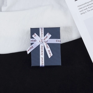 Navy blue jewelry gift box with a white ribbon bow and Crystal Jewelry text print