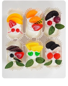 Macro detail of six realistic artificial fruit cupcakes with diverse cream toppings
