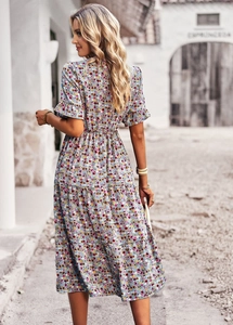 Back view of a floral V-neck midi dress with ruffle sleeves and tiered skirt on a sunny street