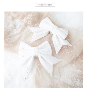 Macro view of white pearlescent sequin Christmas bows with shimmering fabric texture