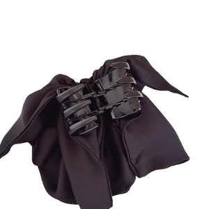 Elegant black satin bow hair claw clip for ponytail styling in a minimalist design