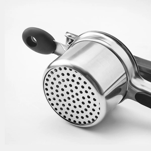 Stainless steel potato masher with black silicone handle and round hole base on white background