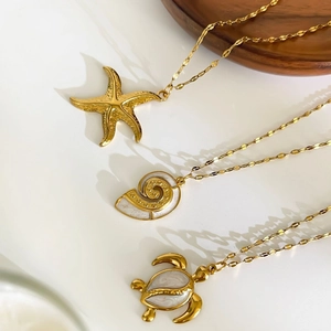 Ocean themed 18K gold plated titanium necklaces featuring starfish, nautilus and turtle pendants
