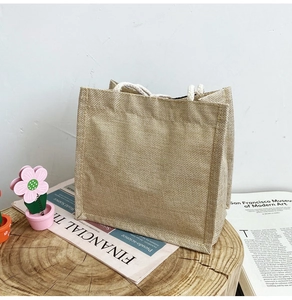 Detail of natural jute tote bag with cotton rope handles on a wooden display stand