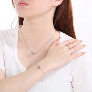 Gros plan d'un ensemble de bijoux nœud argenté avec collier, bracelet et bague sur mannequin