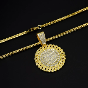 Macro shot of gold hip-hop necklace with iced-out round pendant and lobster clasp details