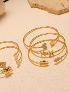 Detailed close-up of 18k gold plated stainless steel bracelets with charms and zircon