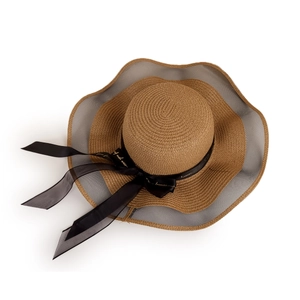 Detailed close-up of straw sun hat with grey mesh brim and black ribbon bow decoration