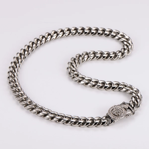 Close-up of silver Cuban link chain with a diamond-encrusted lion head clasp