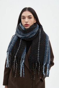 Detail of a black striped scarf with blue and orange spots and fringe edges on a model