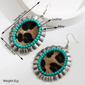 Dettaglio di orecchini pendenti boho con pelle leopardata e perline color turchese