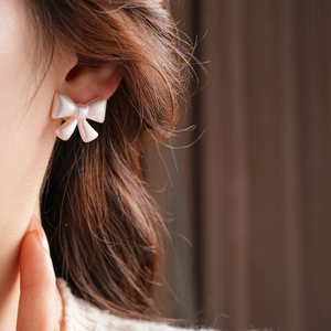 Close-up of pink bow earrings with pearl texture on model for a vintage French aesthetic