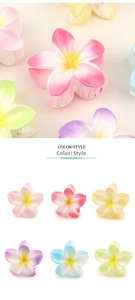 Detail shot of plumeria flower hair claws in pink yellow and blue gradient colors