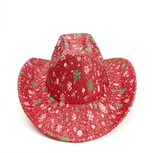 Macro view of red cowboy hat with glitter texture and green snowflake holiday patterns