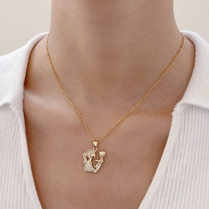 Detail of gold mother and child pendant featuring fine white diamond pavé on a cable chain