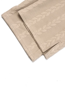 Close-up of beige cable knit texture and side slit detail on casual sports trousers