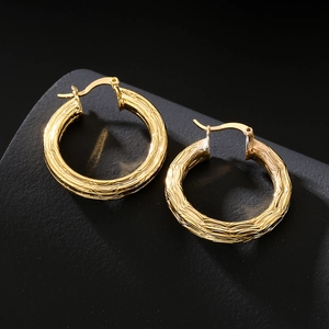 18K gold plated circular earrings with textured hammered finish on dark surface