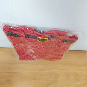 Detail of Christmas Santa pants wine bottle bag in plastic packaging on a wood surface