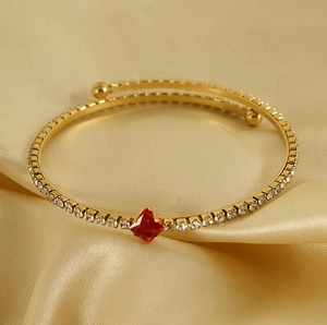 Detail of 18K gold-plated wrap bracelet with pavé cubic zirconia and central red ruby stone