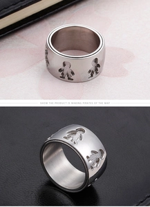 Detail of wide stainless steel ring with cutout boy and girl figures on textured surface