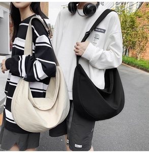 Outdoor shot of models carrying large black and cream oxford crossbody bags