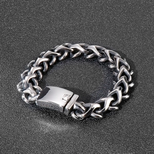 Close-up of chunky stainless steel curb chain bracelet with polished square clasp