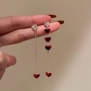 Detailed view of asymmetric heart earrings with red leopard print and shiny rhinestones