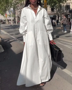 Détail de robe chemise blanche élégante à manches longues avec ourlet fendu et coton frais