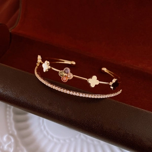 Close-up of double-layer gold flower bangle with colorful zircon on a luxury jewelry box