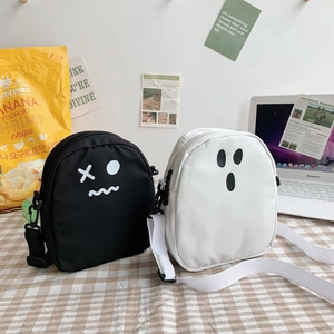 Détail des sacs à bandoulière fantôme en toile noire et blanche sur nappe à carreaux