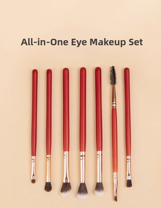Detailed view of 7 professional eye makeup brushes with red handles and gold ferrules