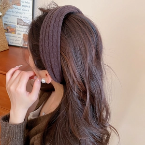 Détail du bandeau en tricot marron avec boucle d'oreille perle dans un cadre chaleureux