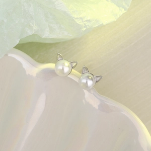 Macro view of cute cat ear pearl earrings with polished silver metal finish