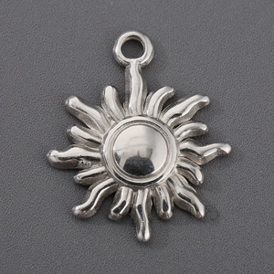 Detailed close-up of a silver sun-shaped pendant made of polished titanium steel