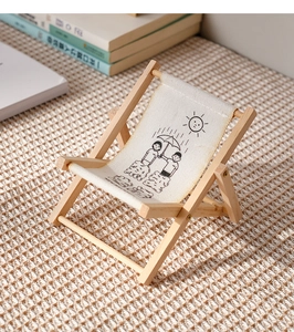 Detailed close-up of a mini wooden folding chair with a cute illustrated fabric seat
