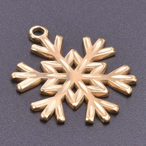 Macro shot of gold snowflake pendant with polished finish and round hanging loop