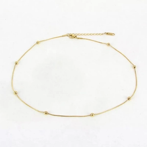 Detailed close-up of golden rose gold bead snake bone chain with lobster clasp and extension