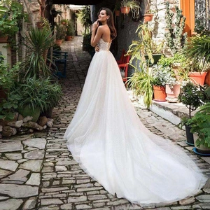 Close-up of white lace embroidery and long mesh train on a luxury wedding gown