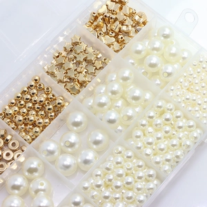 Close-up of DIY jewelry kit with white faux pearls and gold heart star beads in storage box